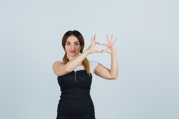 Señora joven rubia en vestido gesticulando aislado