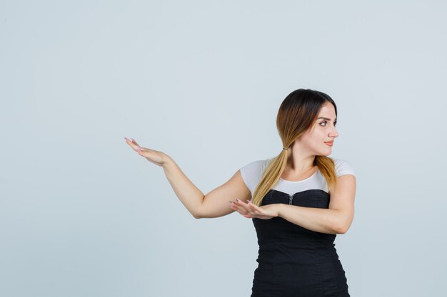 Foto gratuita señora joven rubia en vestido gesticulando aislado