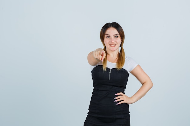 Señora joven rubia en vestido gesticulando aislado