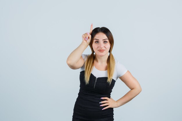 Señora joven rubia en vestido gesticulando aislado