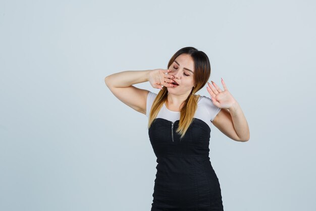 Señora joven rubia en vestido gesticulando aislado