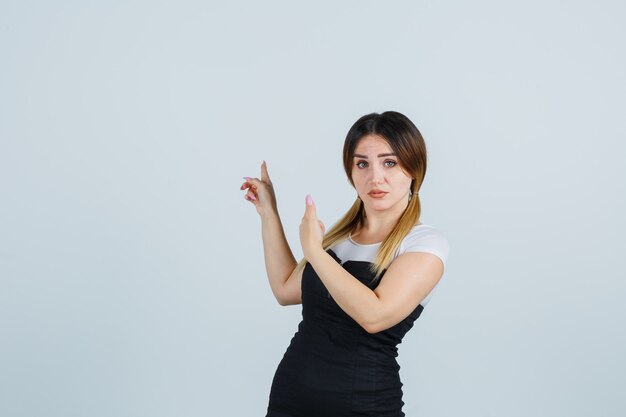 Señora joven rubia en vestido gesticulando aislado