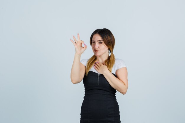 Señora joven rubia en vestido gesticulando aislado