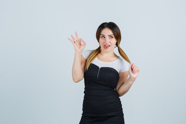 Señora joven rubia en vestido gesticulando aislado