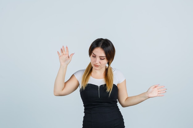 Señora joven rubia en vestido gesticulando aislado