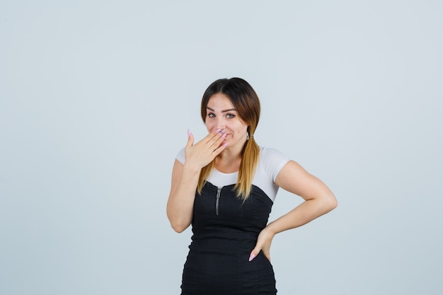 Señora joven rubia en vestido gesticulando aislado