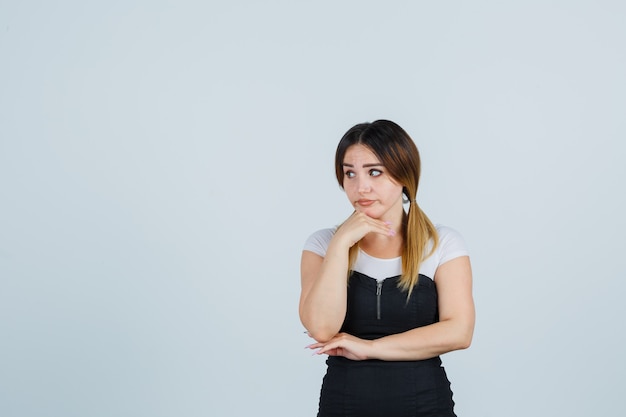 Señora joven rubia en vestido gesticulando aislado