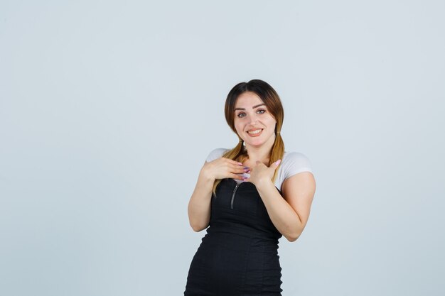 Señora joven rubia en vestido gesticulando aislado