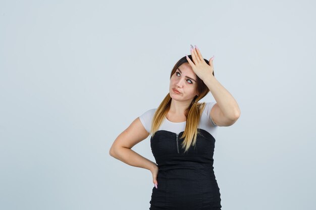 Señora joven rubia en vestido gesticulando aislado