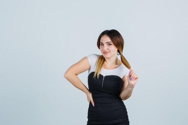 Señora joven rubia en vestido gesticulando aislado