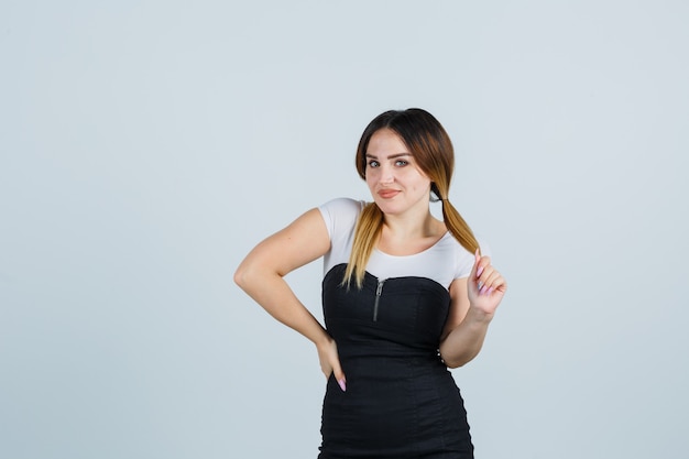 Señora joven rubia en vestido gesticulando aislado