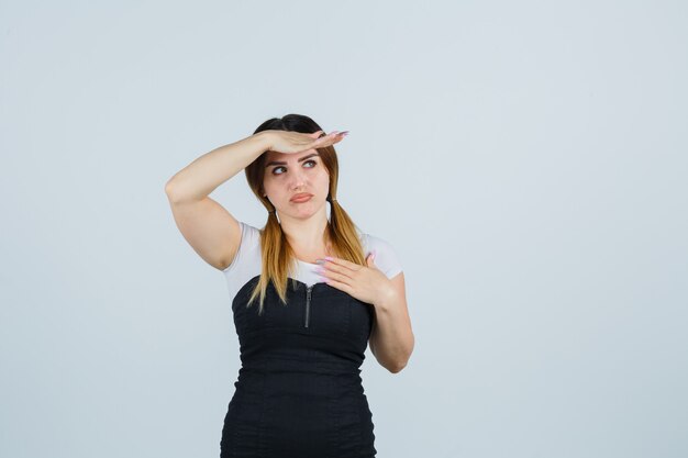 Señora joven rubia en vestido gesticulando aislado