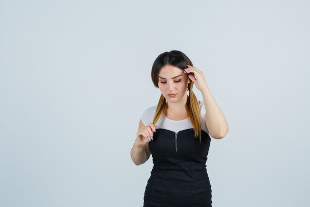 Señora joven rubia en vestido gesticulando aislado