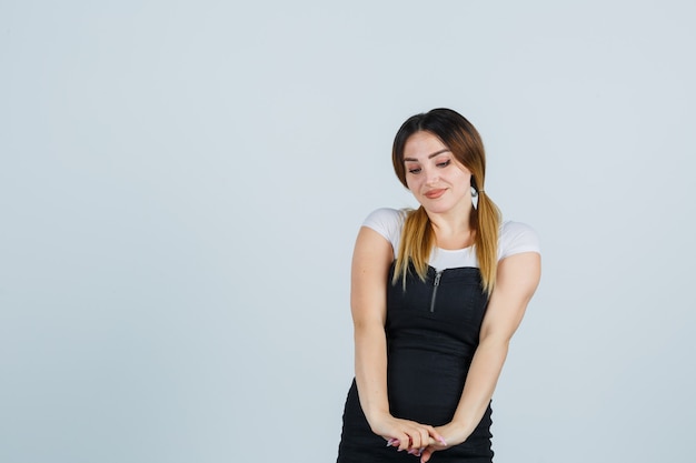 Señora joven rubia en vestido gesticulando aislado