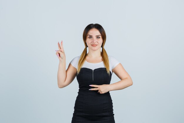 Señora joven rubia en vestido gesticulando aislado