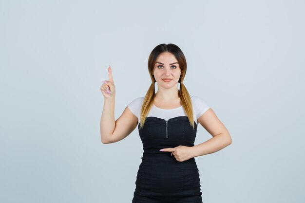 Señora joven rubia en vestido gesticulando aislado