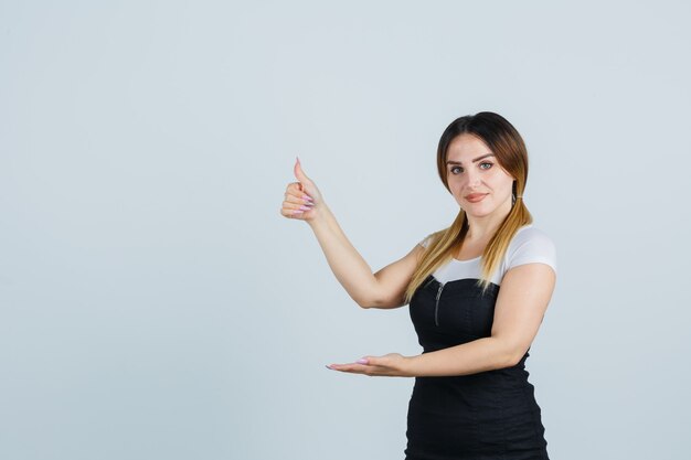 Señora joven rubia en vestido gesticulando aislado