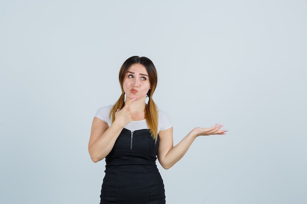 Señora joven rubia en vestido gesticulando aislado