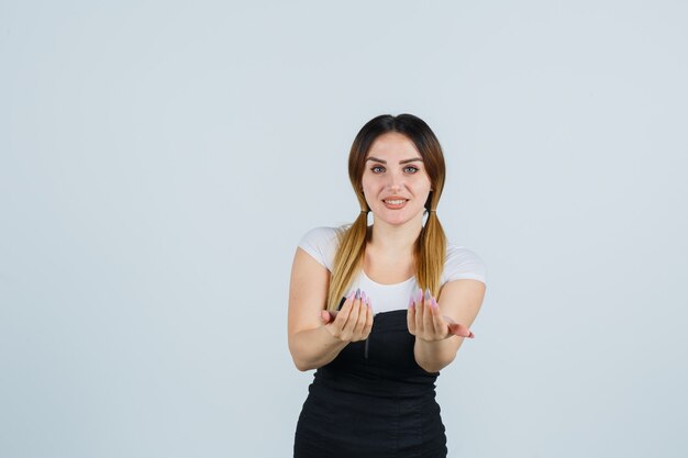 Señora joven rubia en vestido gesticulando aislado