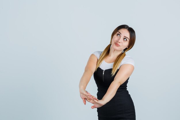 Señora joven rubia en vestido gesticulando aislado