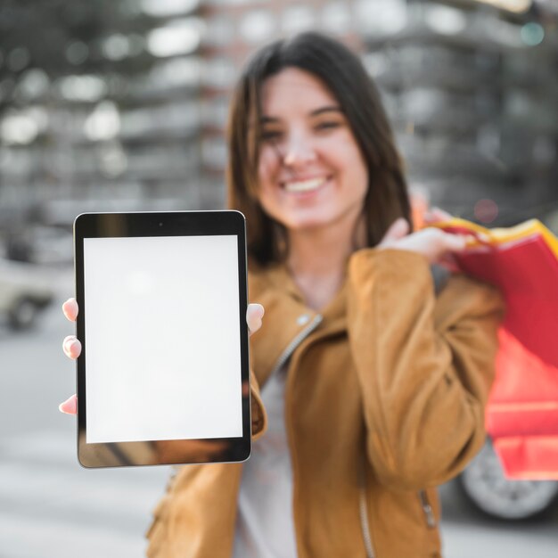 Señora joven sonriente con la tableta