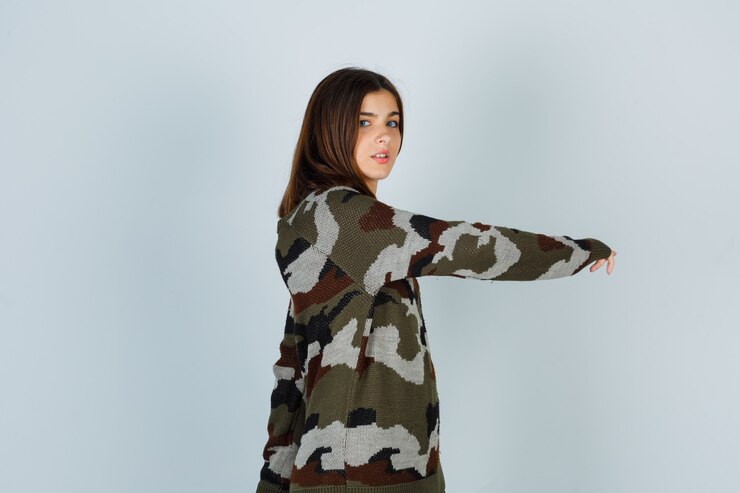 Foto gratuito señora joven en suéter posando mientras se rasca la mano y se ve bien