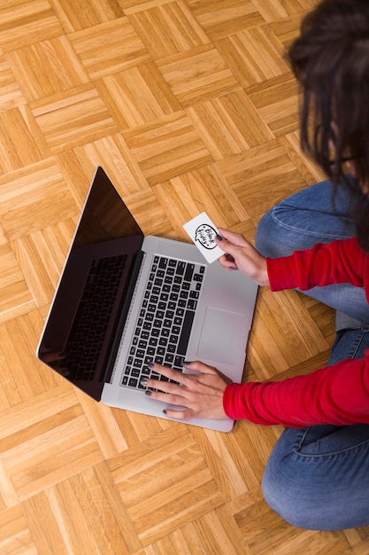 Foto gratuita señora con laptop y tarjeta en piso