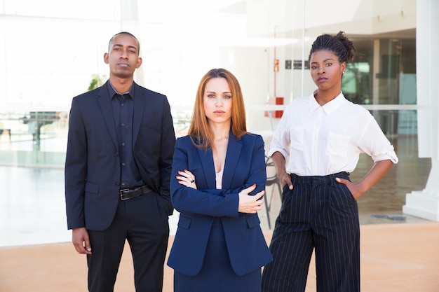 Señora líder de negocios y su equipo mirando a la cámara