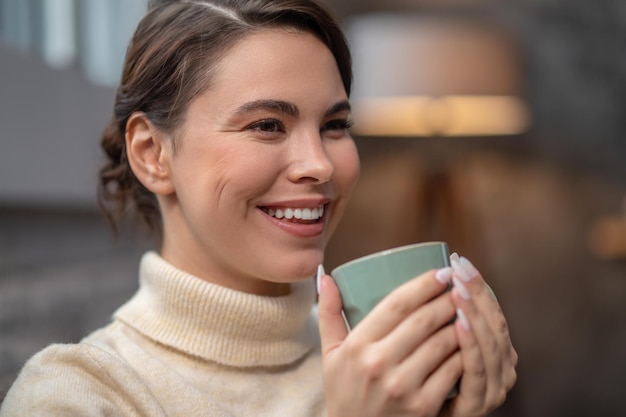 Señora linda feliz que disfruta de su descanso para tomar café