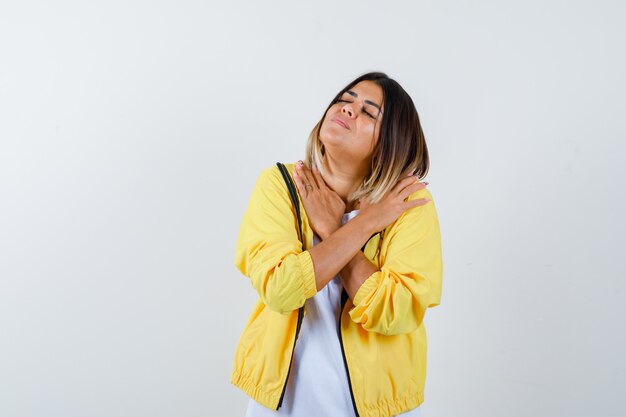 Señora manteniendo los brazos cruzados sobre el pecho en camiseta, chaqueta y luciendo relajada. vista frontal.