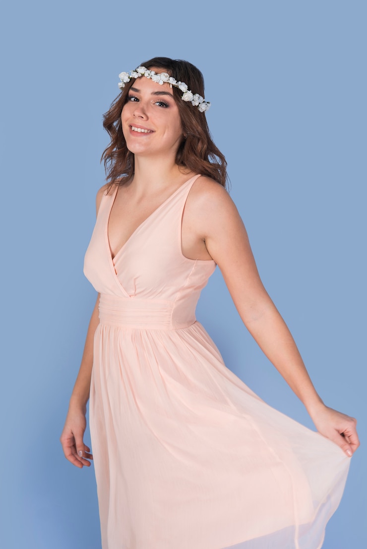 Foto gratuito señora morena feliz joven en vestido rosado con la guirnalda hermosa de la flor