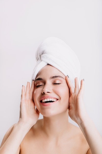 Señora positiva disfruta de un tratamiento de spa matutino. Chica después de la ducha posando en la pared aislada.