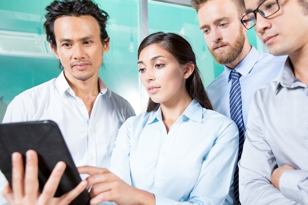 Señora que muestra la información en la tableta a los colegas