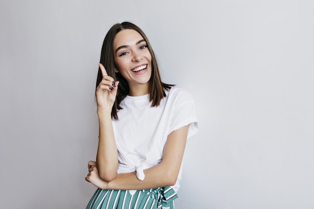 Foto gratuita señora riendo con peinado de moda posando. fascinante modelo femenino en camiseta blanca divirtiéndose