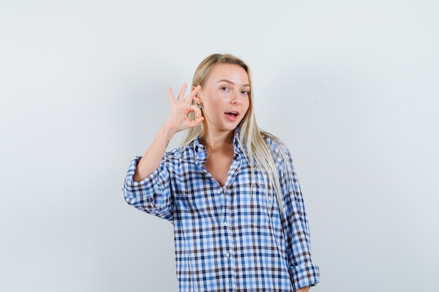 Foto gratuita señora rubia en camisa a cuadros que muestra un gesto bien y parece feliz