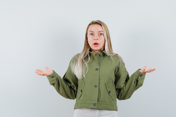 Foto gratuito señora rubia mostrando gesto de impotencia en chaqueta, pantalón y mirando perplejo, vista frontal.