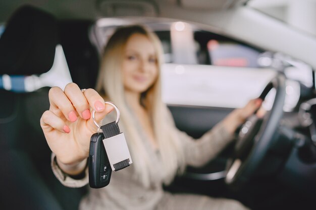 Señora en un salón de autos. Mujer comprando el coche. Mujer elegante con un traje marrón.