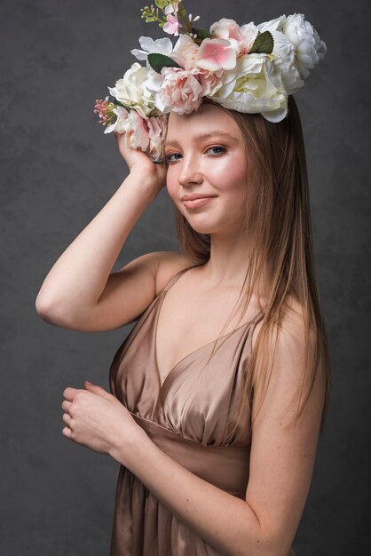 Señora sensual alegre joven en vestido con la guirnalda hermosa de la flor