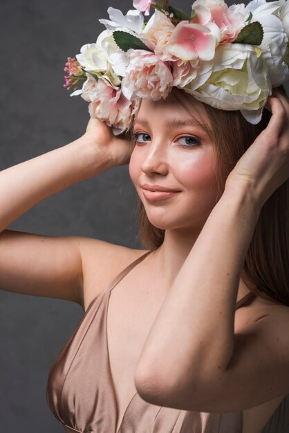 Señora sensual joven en vestido con la guirnalda hermosa de la flor