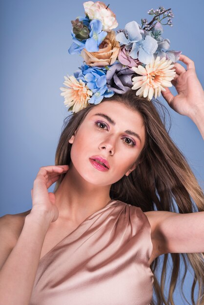 Señora sensual joven en vestido con hermosas flores en la cabeza