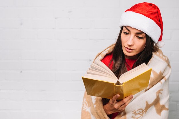 Señora en sombrero de fiesta leyendo libro