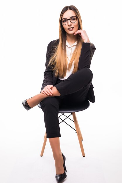 Señora sonriente con gafas sentado en una silla negra sobre blanco