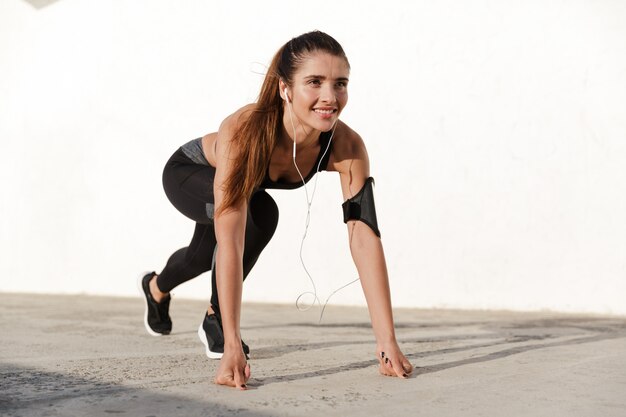 Señora sonriente haciendo ejercicios mientras entrena