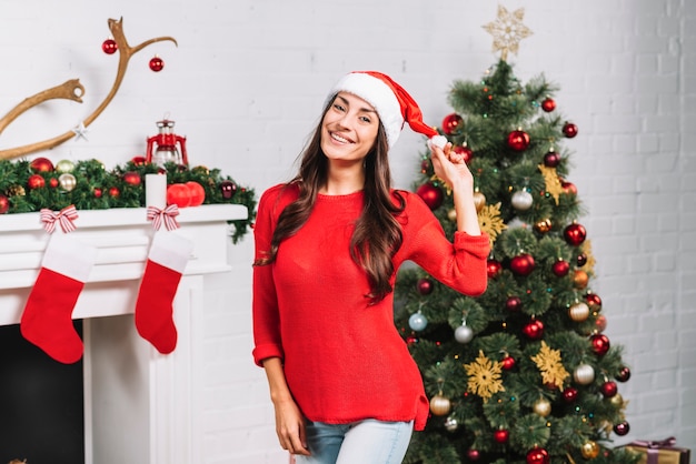 Señora sonriente joven en sombrero de la Navidad