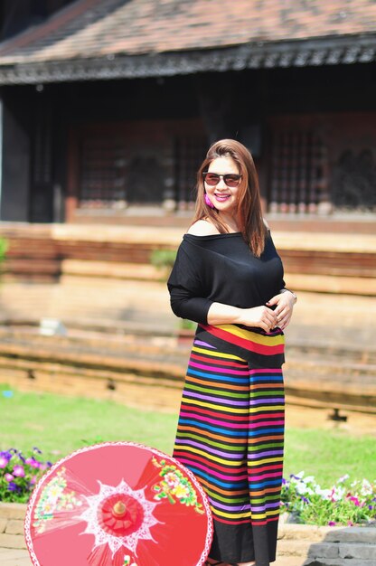 Señora tailandesa de mediana edad en un colorido traje de estilo del norte de Tailandia en un lugar turístico al aire libre en Chiang Mai Lanna Tailandia