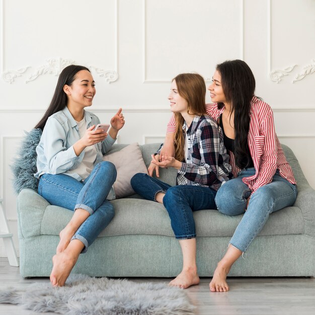 Señoras sentadas en el sofá y charlando