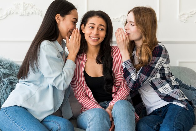 Señoras susurrando en el oído de amigos secreto