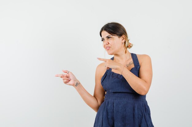 Señorita apuntando hacia el lado en vestido