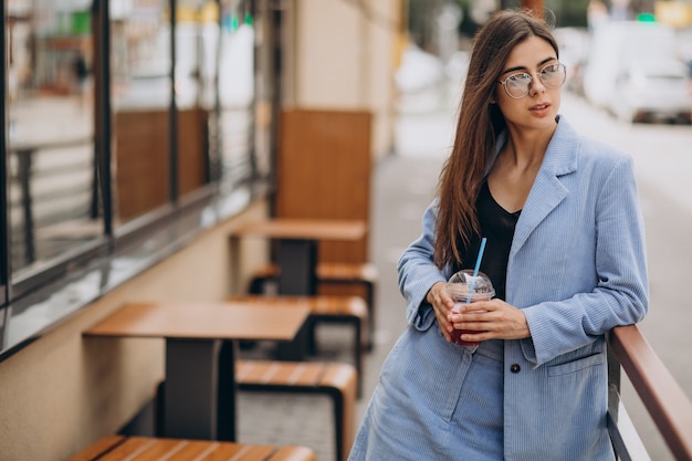 Foto gratuita señorita bebiendo bebida helada fuera de la calle