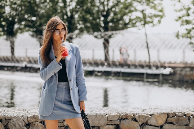 Señorita bebiendo té helado en el parque